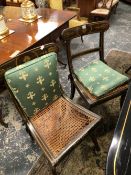 A SET OF SIX REGENCY EBONISED DINING CHAIRS, THE TOP RAILS GILT WITH FLOWER HEADS FLANKED BY