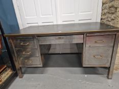 A PEDESTAL DESK WITH THE BLACK TOP SUPPORTED ON STEEL SIDES AND SQUARE LEGS, THE CENTRAL DRAWER