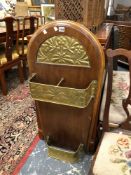 AN ARTS AND CRAFTS MAHOGANY AND BRASS STICK STAND WITH A ROUND ARCHED BACK TO THE FLORAL BRASS WORK
