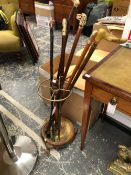 A BRASS AND MAHOGANY CIRCULAR STICK STAND TOGETHER WITH SIX WALKING STICKS