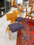 A SET OF FOUR ROBIN DAY CHAIRS WITH BROAD PLYWOOD BACK RESTS RAISED ON RECTANGULAR PANELS ABOVE