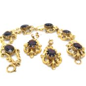 A VICTORIAN STYLE 9ct HALLMARKED GOLD AND GARNET ORNATE BRACELET AND EARRING SUITE. GROSS WEIGHT