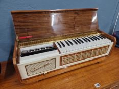 A FARFISA PIANORGAN CASED WITH ITS KEYS AND SOUND SYSTEM IN A WALNUT CASE