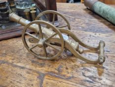 A BRASS MODEL CANNON ON A TWO WHEEL CARRIAGE, THE BARREL. 26cms