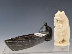 A 1967 INUIT BLACK STONE CARVING OF A MAN LAUNCHING HIS FISHING BOAT. W 16cms. TOGETHER WITH AN