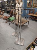 A PAIR OF CHROME TWIN COLUMN STANDS ON SQUARE FEET, THE ARMS AT THE TOP AT RIGHT ANGLES TO THE
