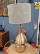 A BRUSHED COPPER TABLE LAMP, THE PEAR SHAPE DIVIDED AT ITS GIRTH AND LIT WITHIN BY A SECOND LIGHT