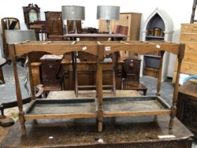 AN EARLY 20th C, OAK STICK STAND WITH TWELVE COMPARTMENTS ABOVE TWO IRON DROP IN TRAYS AND SPINDLE