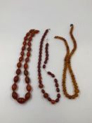 A STRAND OF FACETED AMBER GRADUATED BEADS, TOGETHER WITH A ROW OF CARNEILIAN BEADS AND A PART ROW OF