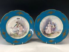 A PAIR OF 19th C. SEVRES PLATES PAINTED BY C. VELLY WITH COUPLES IN LANDSCAPES WITHIN FLORAL GILT