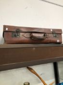 A LEATHER SUITCASE.