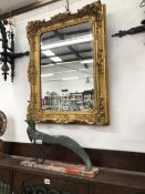 A RECTANGULAR MIRROR WITHIN A GILT FRAME WITH SHELLS AND SCROLLING FOLIAGE ON ITS SIDES. 77 x