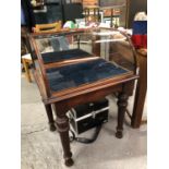 AN ANTIQUE MAHOGANY FRAMED DISPLAY CASE WITH CURVED GLASS TOP. RAISED ON TURNED LEGS. 65 X 54 X 92