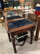 AN ANTIQUE MAHOGANY FRAMED DISPLAY CASE WITH CURVED GLASS TOP. RAISED ON TURNED LEGS. 65 X 54 X 92