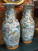 A PAIR OF CANTON VASES PAINTED WITH FIGURE RESERVES ON A GROUND OF FLOWERS, FRUIT AND BUTTERFLIES,