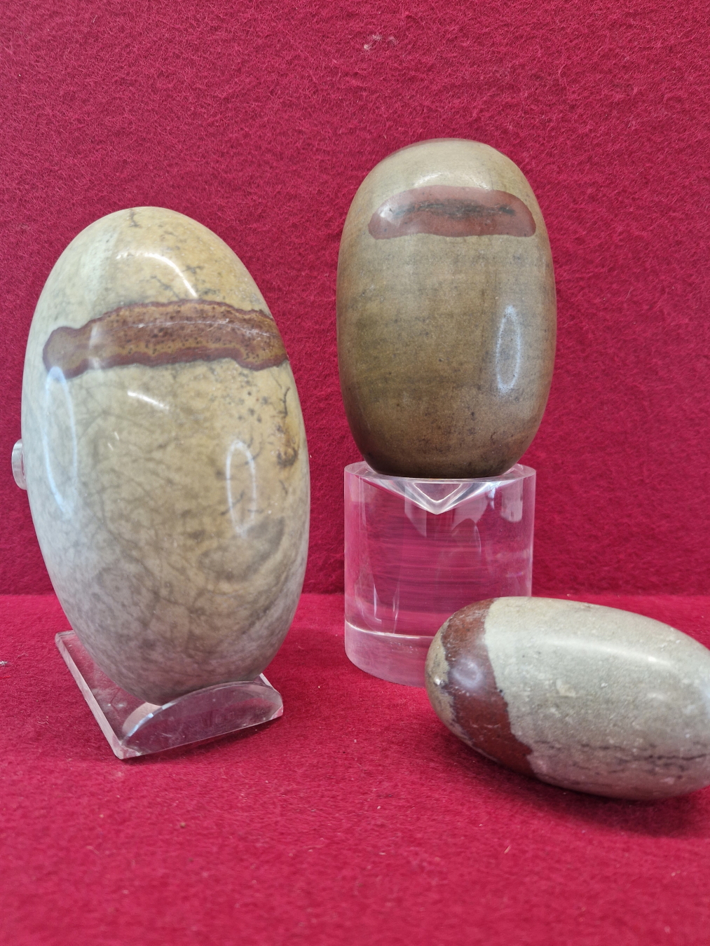 THREE INDIAN SHIVA LINGAM STONE OF LARGE SIZE EACH OF GREYISH STONE WITH RED LINE INCLUSIONS.