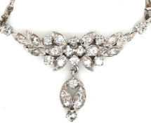 A DIAMOND SET FLORAL DESIGN NECKLACE WITH A DIAMOND SET DROPPER SUSPENDED ON A HAYSEED CHAIN.