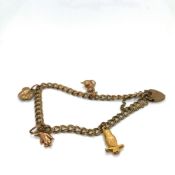 A 9ct HALLMARKED GOLD CHARM BRACELET, COMPLETE WITH PADLOCK CLASP, SAFETY CHAIN AND FOUR 9ct GOLD