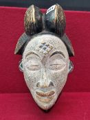 AN AFRICAN WOODEN MASK, POSSIBLY PUNU, THE WHITENED FACE WITH A DIAMOND SHAPED SCAR ON THE