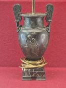 A SPELTER TWO HANDLED CLASSICAL URN AS A TABLE LAMP, THE BALUSTER SHAPE CAST IN LOW RELIEF WITH