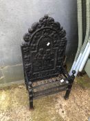 A SMALL CAST IRON FIRE BASKET WITH PICTORIAL IRON BACK