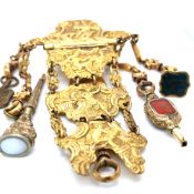AN 18th CENTURY GILDED CHANTELAINE WITH RAISED PICTORIAL DECORATION, COMPLETE WITH VARIOUS FOBS