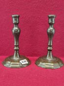 A PAIR OF 18th C. BRONZE CANDLESTICKS WITH THE INVERTED BALUSTER COLUMNS RAISED ON SHAPED CIRCULAR