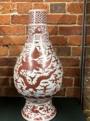 A CHINESE BALUSTER VASE PAINTED IN IRON RED WITH TWO DRAGONS CHASING A FLAMING PEARL ABOVE ROCKS AND