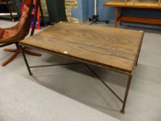 AN OAK TOPPED COFFEE TABLE ON BLACKENED IRON LEGS JOINED BY AN X-SHAPED STRETCHER. W 120 x D 80 x