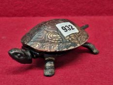 A VINTAGE TABLE BELL IN THE FORM OF A TORTOISE, THE CLOCKWORK WOUND BELL SOUNDING WHEN THE HEAD OR