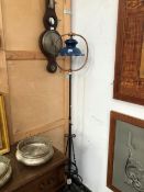 A WROUGHT IRON AND COPPER ADJUSTABLE STANDARD LAMP WITH A BLUE GLASS SHADE