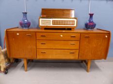 A 1970S SIDEBOARD WITH THE CENTRAL THREE DRAWERS FLANKED BY CUPBOARDS ABOVE TAPERING SQUARE