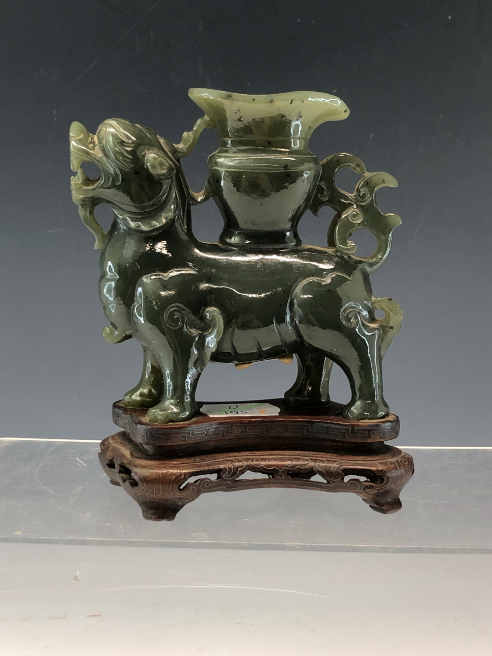 A CHINESE GREEN HARDSTONE FIGURE OF A QILIN WITH A VASE ON ITS BACK. W 11cms. TOGETHER WITH ITS