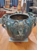 A CLEMENT MASSIER GREEN GLAZED MAJOLICA PLANTER WITH FOUR SATYR MASK HANDLES WITH THEIR HORNS