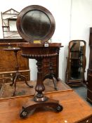 AN EARLY VICTORIAN ROSEWOOD TEAPOY WITH A GADROONED BASE AND BALUSTER COLUMN ON A TRIPARTITE