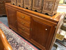 A CONTEMPORARY CHINESE HARD WOOD SIDEBOARD WITH FOUR DRAWERS FLANKED BY CUPBOARDS. W 152 x D 48 x