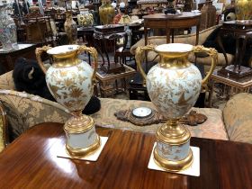 A PAIR OF EARLY 20th C. TWO GILT HANDLED PALE TURQUOISE GROUND POTTERY VASES AND STANDS