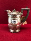 A BASALLY GADROONED SILVER COFFEE POT BY CARRINGTON, LONDON 1906, WITH A BLACK BAKELITE HANDLE AND