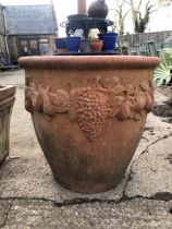 A LARGE TERACOTTA TERRACE PLANTER WITH FRUITING VINE DECOARATION.