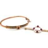 AN ANTIQUE 9ct STAMPED SEED PEARL AND GEMSET HINGED BANGLE WITH CENTRAL HEART MOTIF AND ATTACHED