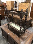A LATE STUART STYLE OAK STICK STAND WITH A BRASS HANDLE ON THE DIVISION CENTRAL TO THE TOP AND