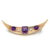 A VINTAGE DIAMOND AND AMETHYST CRESCENT MOON BROOCH. THE CENTRAL AMETHYST AN EMERALD CUT,