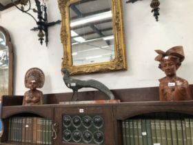 A PAIR OF MALAYSIAN CARVED WOOD BUSTS OF A MAN AND HIS WIFE BOTH WEARING HEAD DRESSES