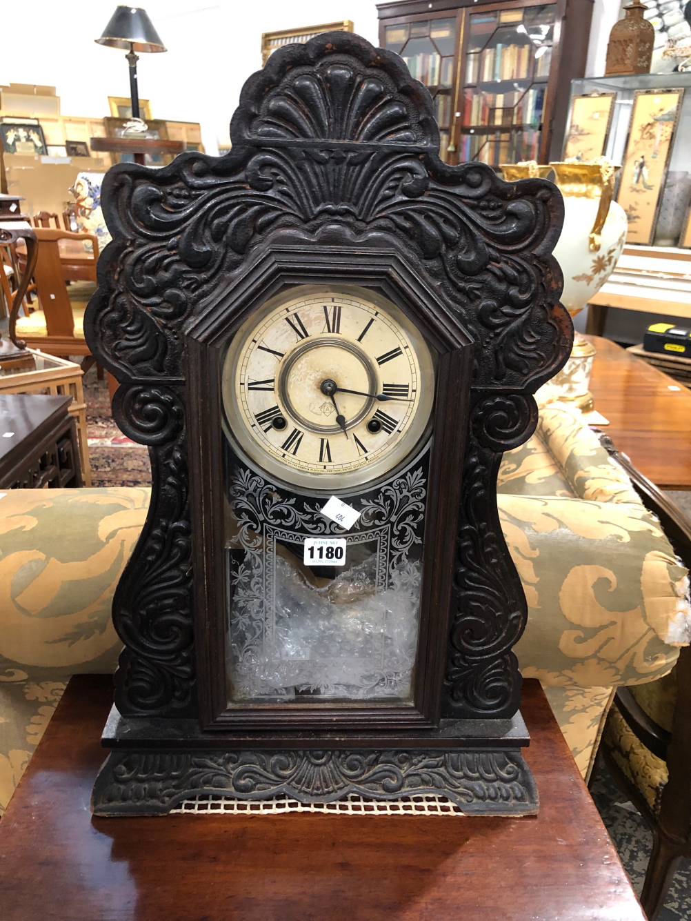 AN ANSONIA CLOCK STRIKING ON A COILED ROD AND WITHIN A GLAZED STAINED WOOD CASE. H 56cms.