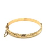 A VINTAGE 9ct HALLMARKED GOLD HINGED BANGLE COMPLETE WITH ATTACHED SAFETY CHAIN. DATED 1994,