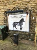 A LARGE WROUGHT IRON SIGN POST HANGER WITH SWINGING SIGN FOR THE BLACK HORSE