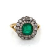A LATE 19th CENTURY CIRCA 1870 EMERALD AND DIAMOND CLUSTER RING SET WITH A PRINCIPLE EMERALD CUT