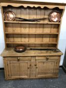 AN ANTIQUE PINE DRESSER THE ENCLOSED SHELF BACK ABOVE PAIRS OF DRAWERS OVER DOORS AND THE PLINTH
