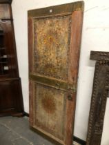 A MIDDLE EASTERN PAINTED TWO PANELLED DOOR CLOSE NAILED WITH THREE BRASS BANDS