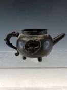A CHINESE BRONZE MINIATURE KETTLE WITH DRAGON ROUNDELS IN RELIEF FLANKING THE DRAGON HANDLE ABOVE